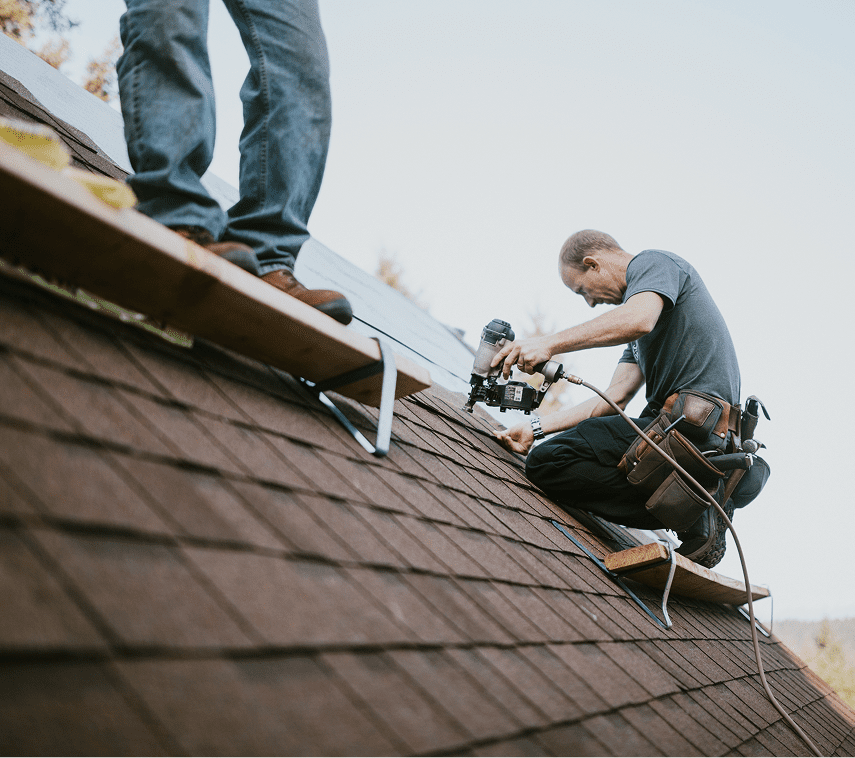 Men installing shingles on roof