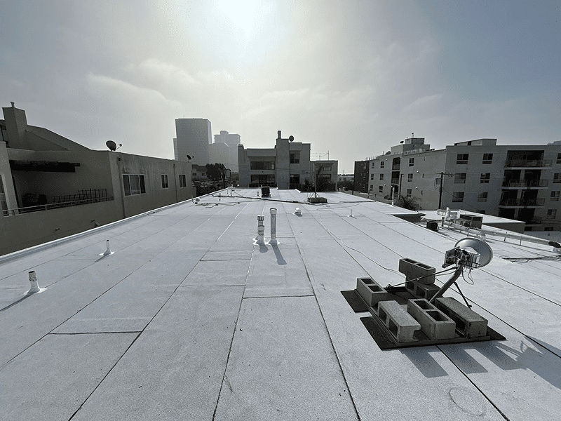A flat rooftop under bright sunlight with some construction materials.