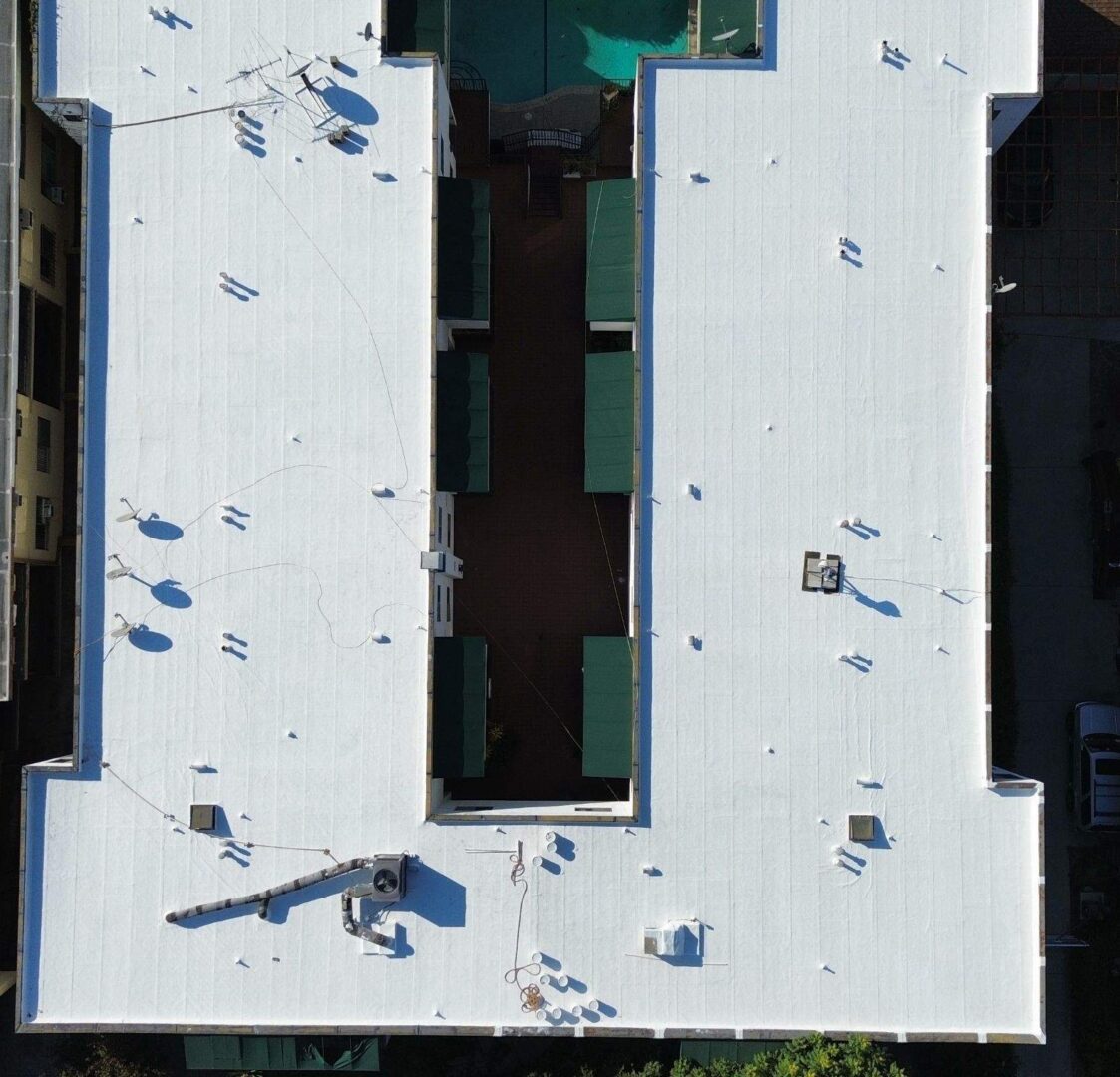 Aerial view of a white rooftop with scattered people and shadows.