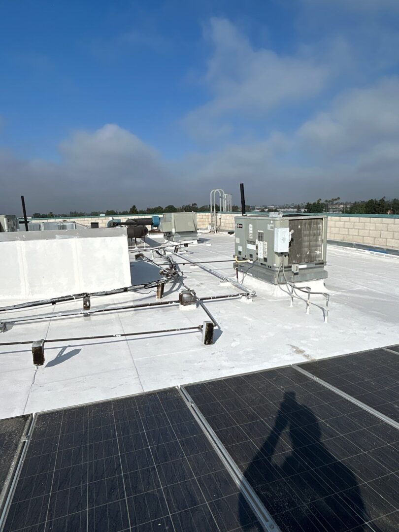 Solar panels installed on a white rooftop under a clear sky.