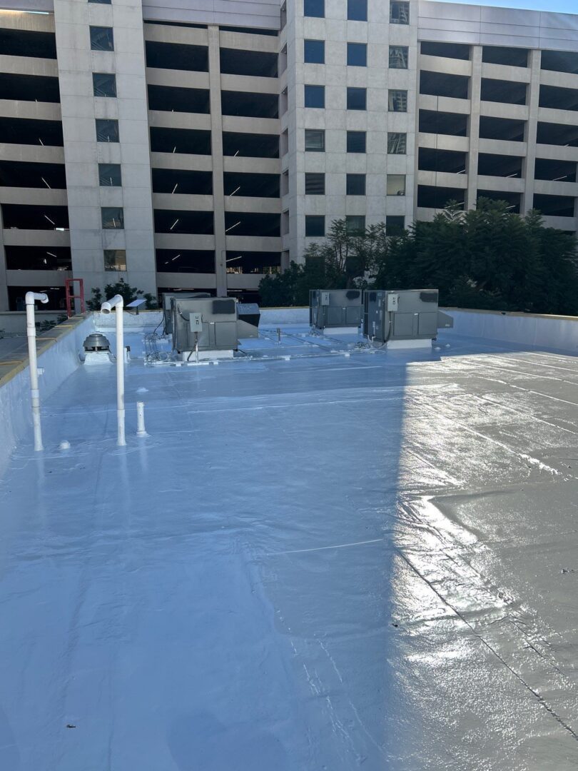 A newly coated white rooftop reflecting sunlight in an urban setting.