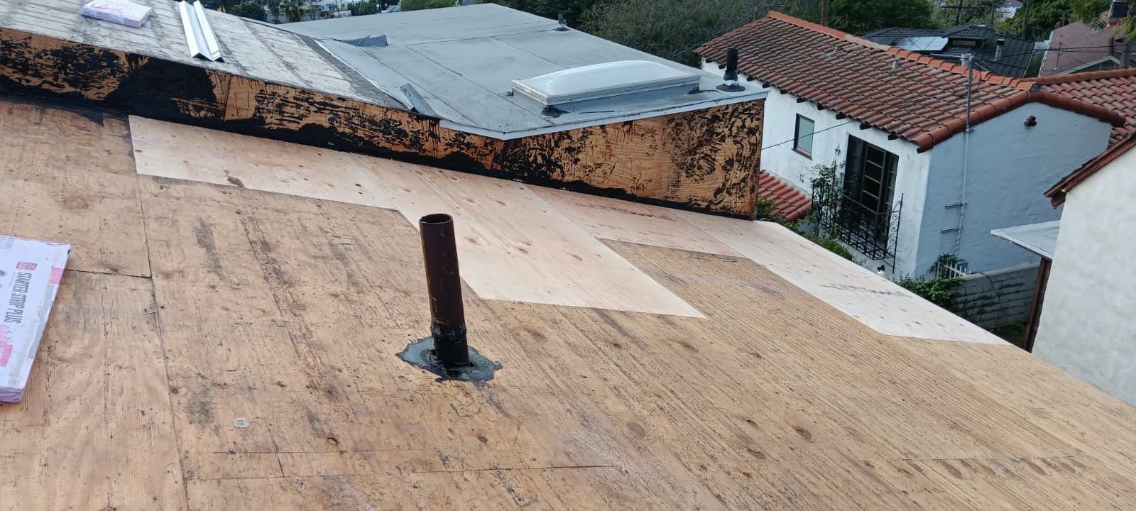Roof under repair with a vent pipe visible.