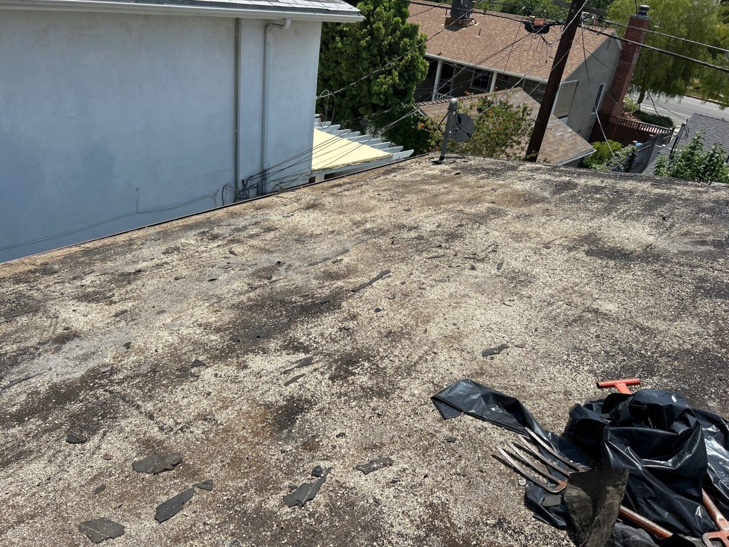 Worn asphalt shingle roof with some damage and debris.
