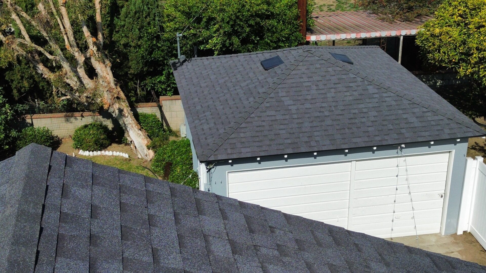 Aerial view of rooftops with green trees in the background.