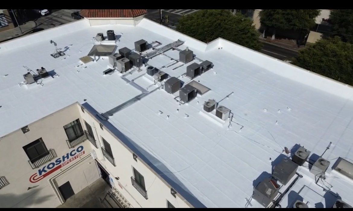 Rooftop with multiple HVAC units installed on a white flat roof.