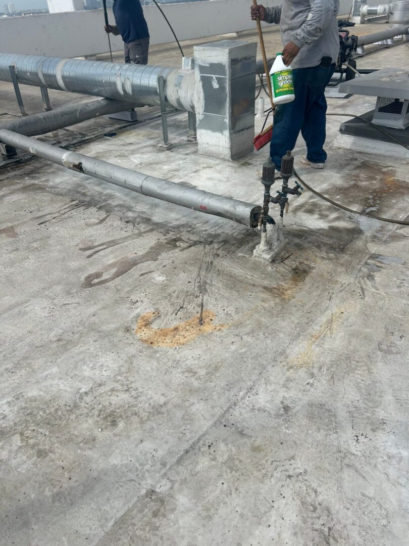 Worker using a jackhammer on a concrete floor indoors.