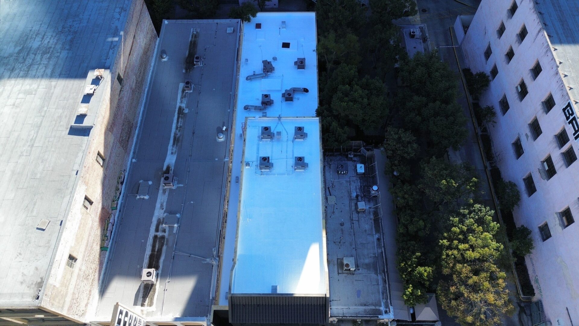 Aerial view of buildings with a brightly lit rooftop at dusk.