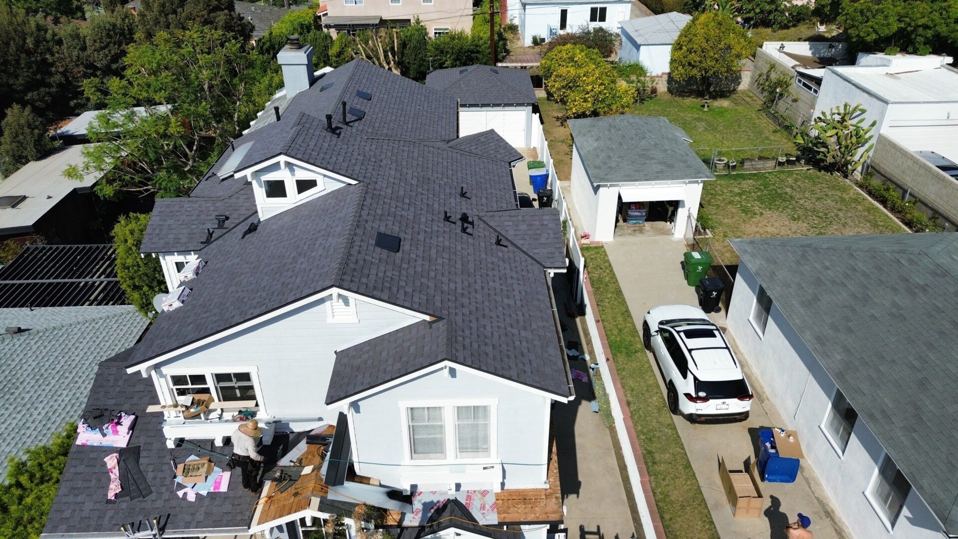 Aerial view of a residential area with houses and parked cars.