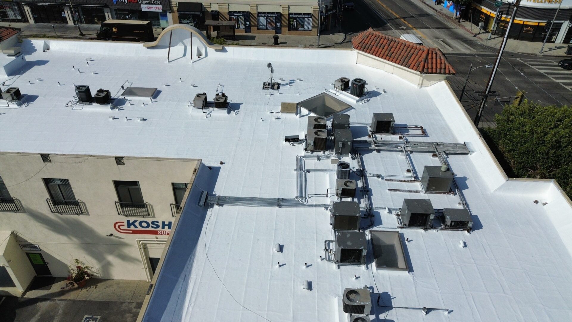 A rooftop covered with white material and various HVAC units installed.