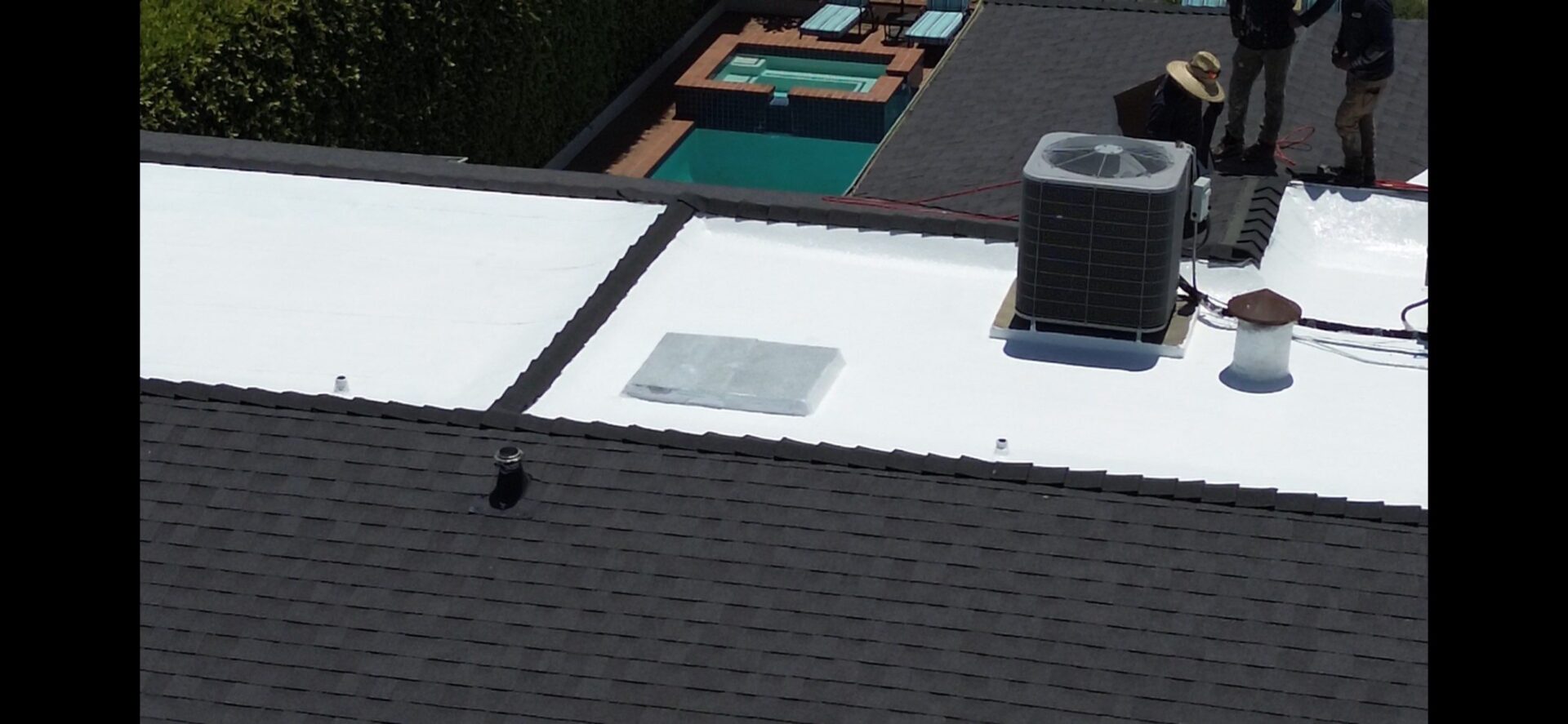 A white flat roof with an air conditioning unit and a skylight.
