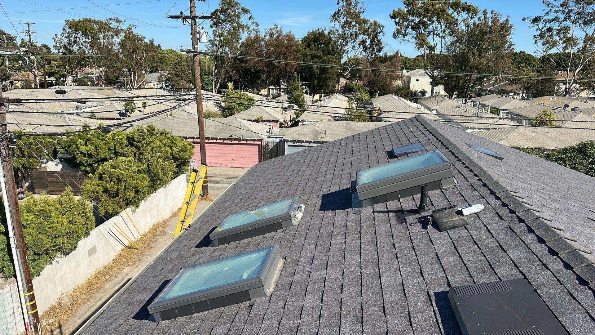 Roof with solar water heater and skylights under a clear sky.