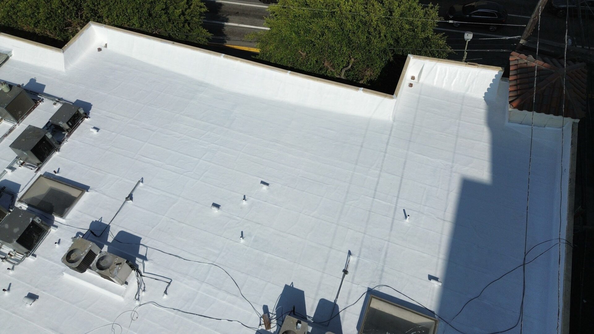 A white rooftop with some equipment and shadows visible.