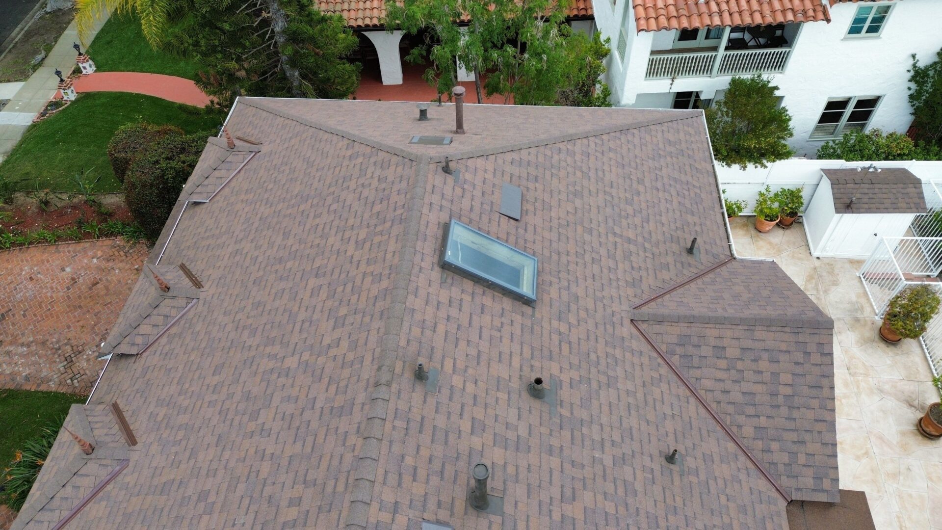 A residential roof with a skylight and various vents.