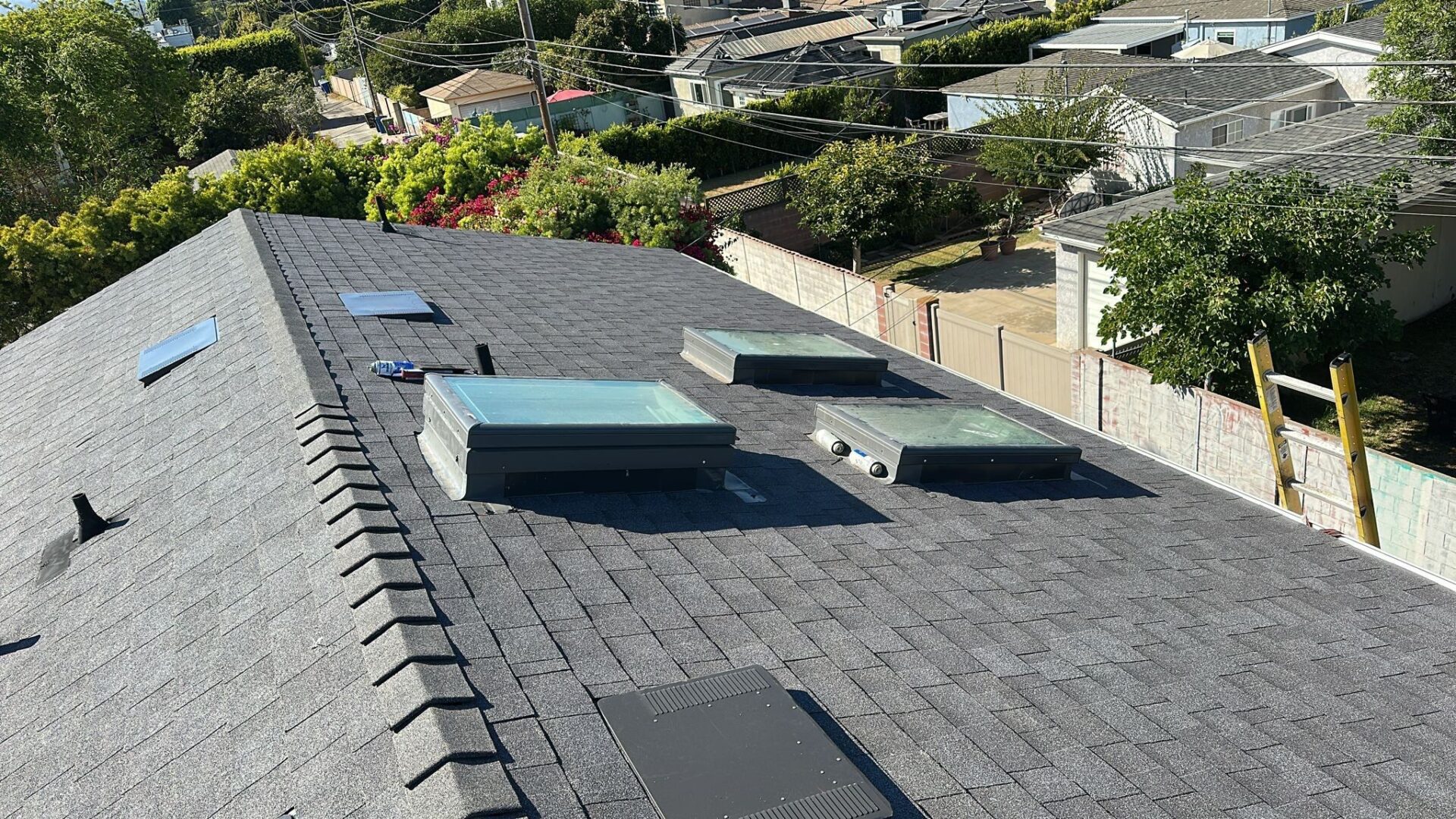 Newly installed residential roof with vents in a sunny neighborhood.