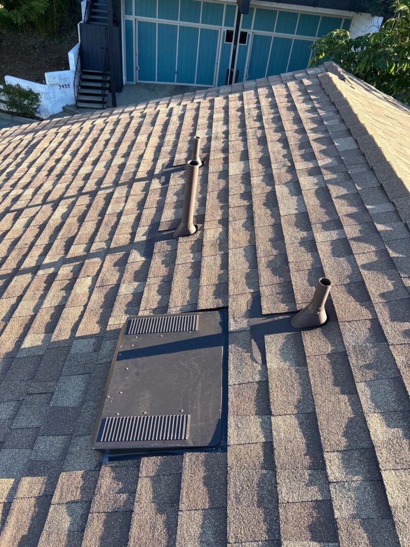 Roof with solar panel mounts and a vent pipe.