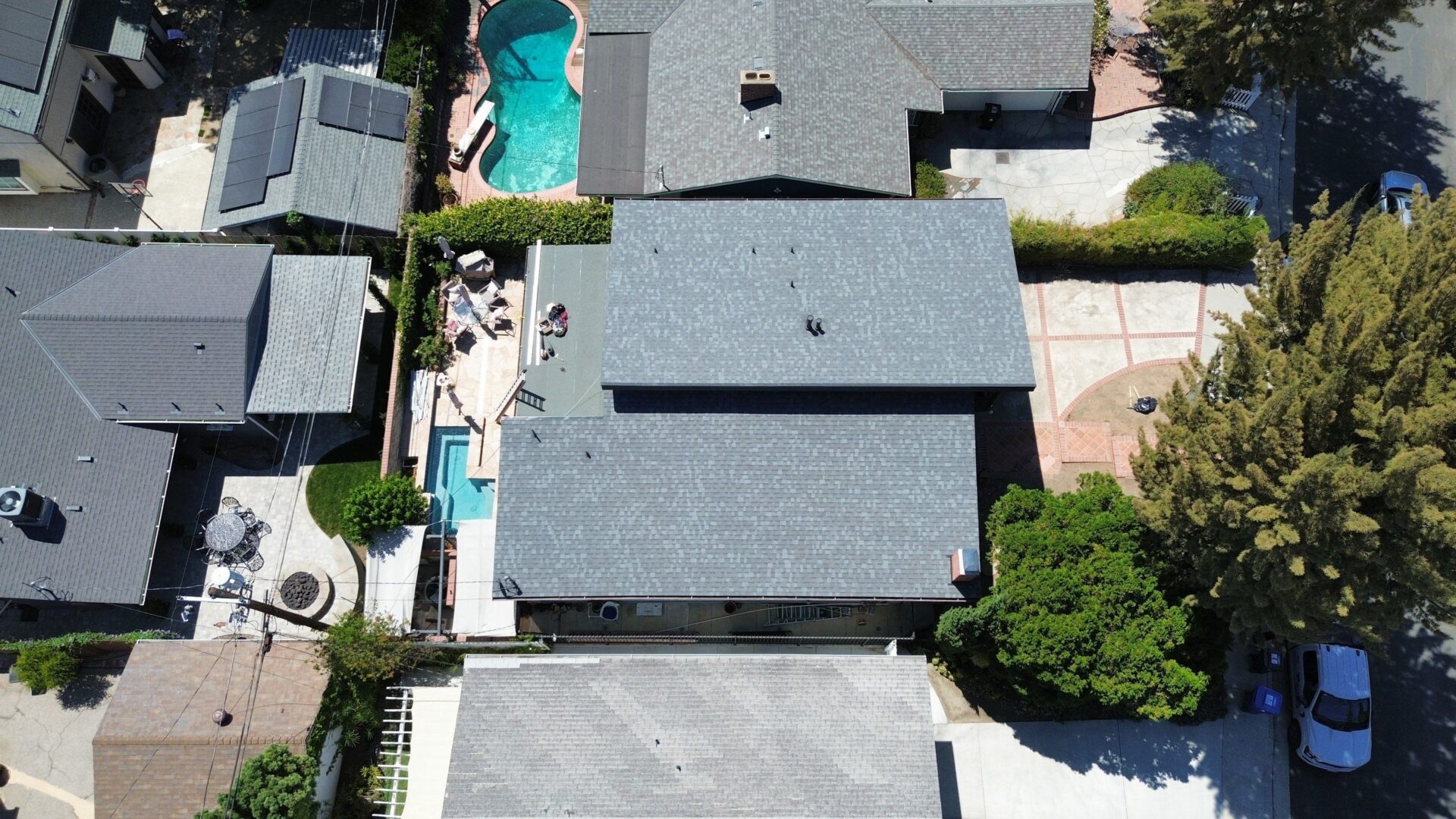 Aerial view of a residential house with a swimming pool in the backyard.