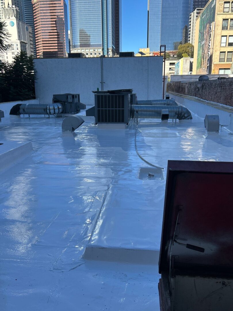 Newly coated shiny white rooftop on an urban building under daylight.