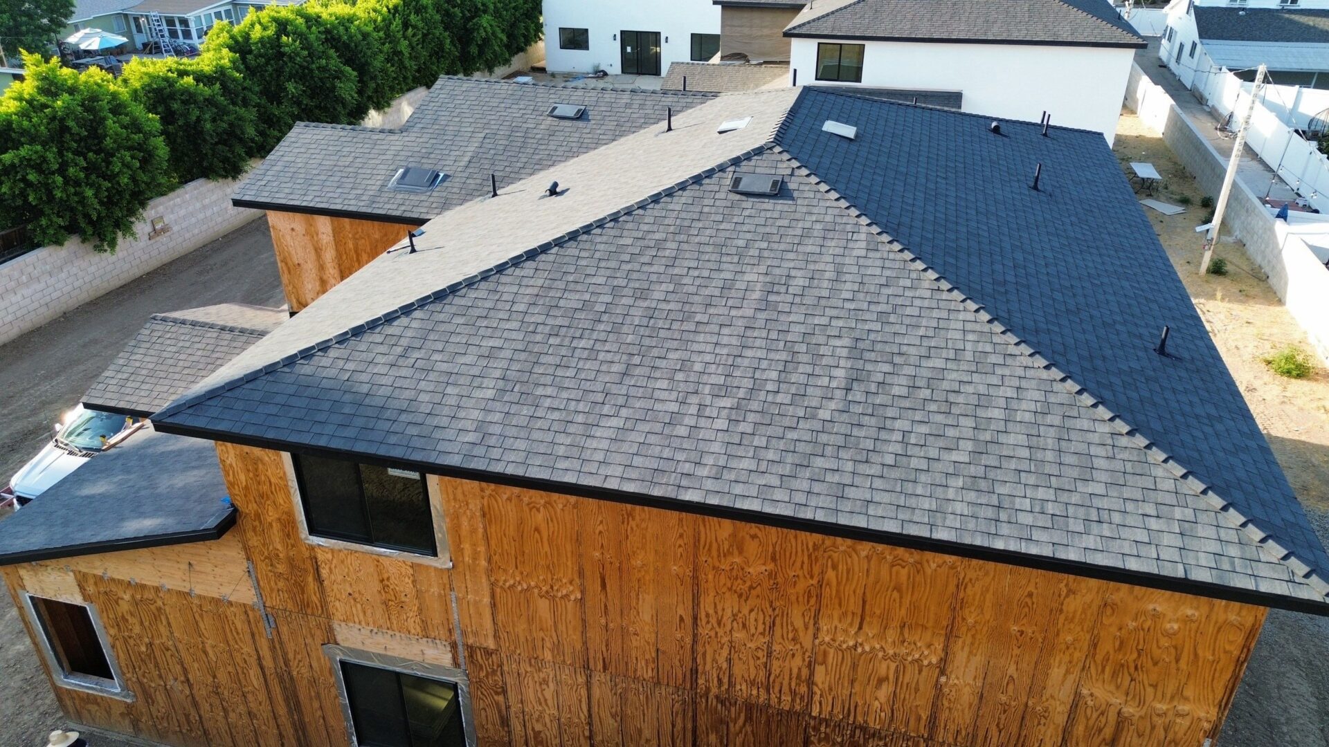 Modern house with a dark shingled roof and wooden siding.