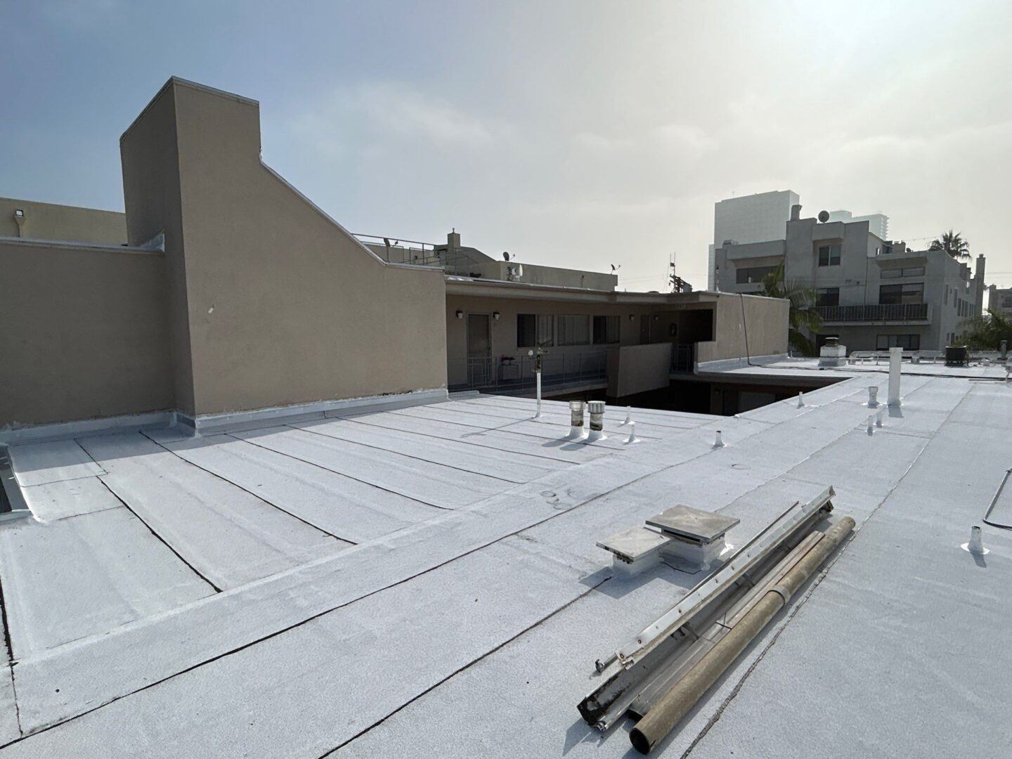 Flat rooftop with construction materials under a clear sky.