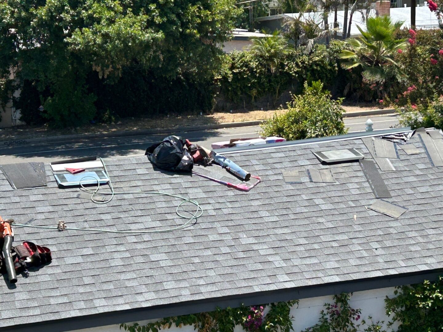 Person lying on a rooftop surrounded by tools and papers.