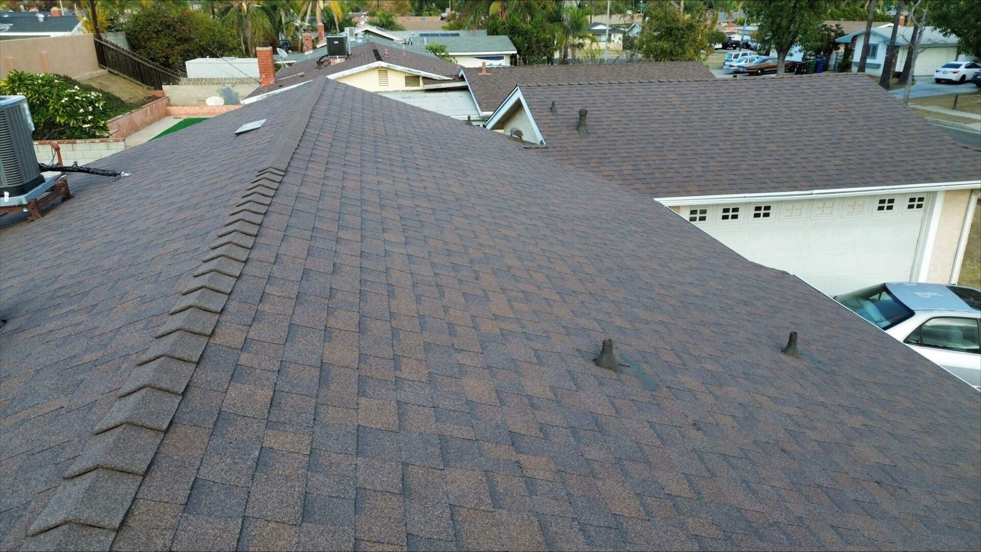 A long rooftop covered in brown shingles under clear weather.