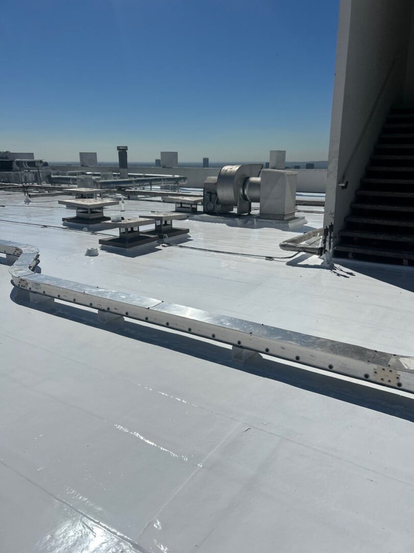 Rooftop with HVAC units under a clear blue sky.