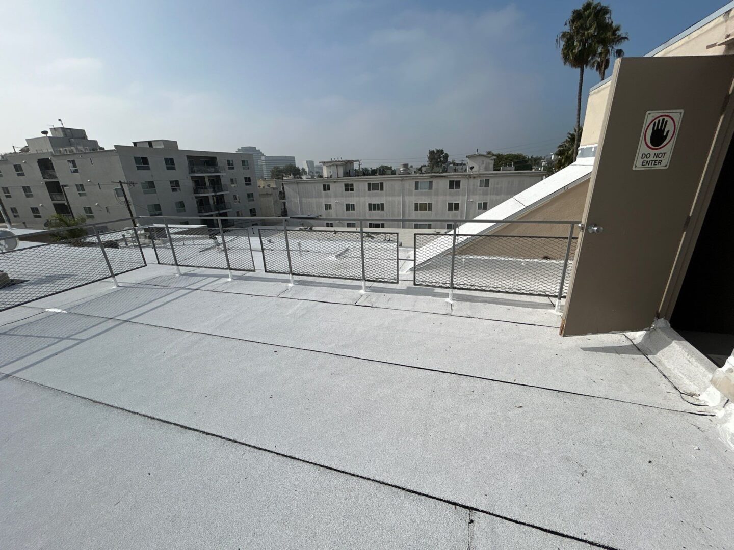Empty rooftop with metal railings under a clear sky.