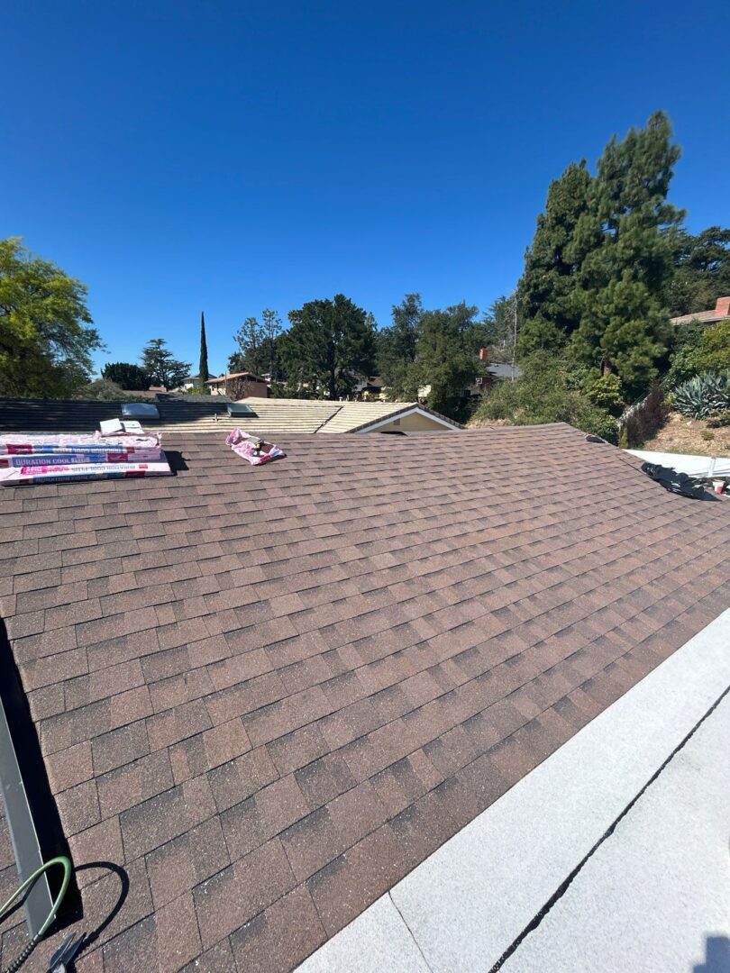 View of a newly shingled roof under a clear sky.