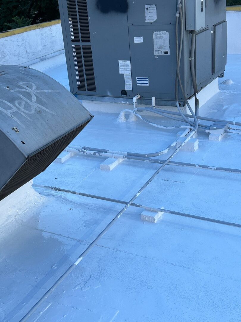 Close-up of a rooftop with icy surface and a black vent.