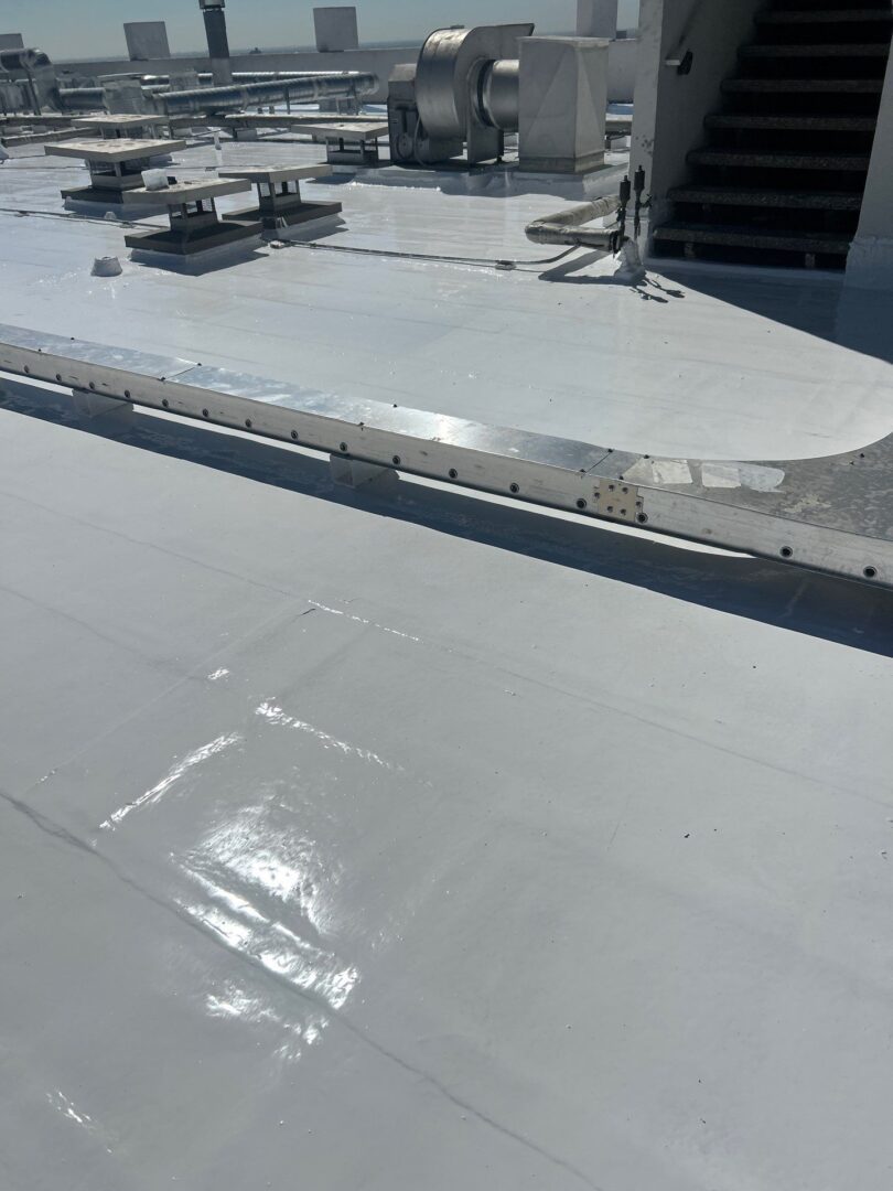 Flat rooftop with smooth, gray waterproof coating applied.