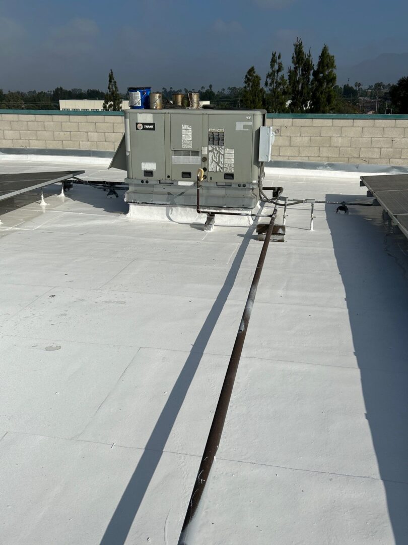 Rooftop HVAC units with exposed wiring on a white roof surface.