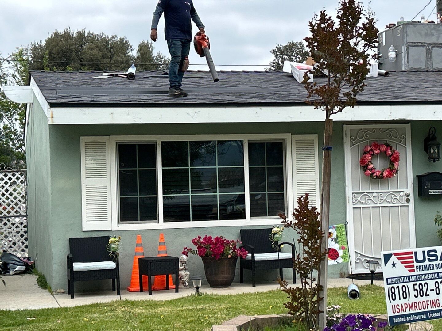 Person walking on a roof carrying a tool bag.