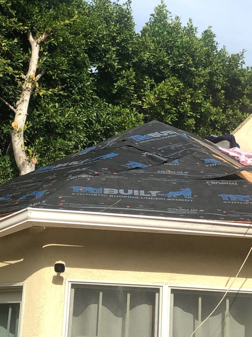 Roof under construction with protective underlayment partially installed.