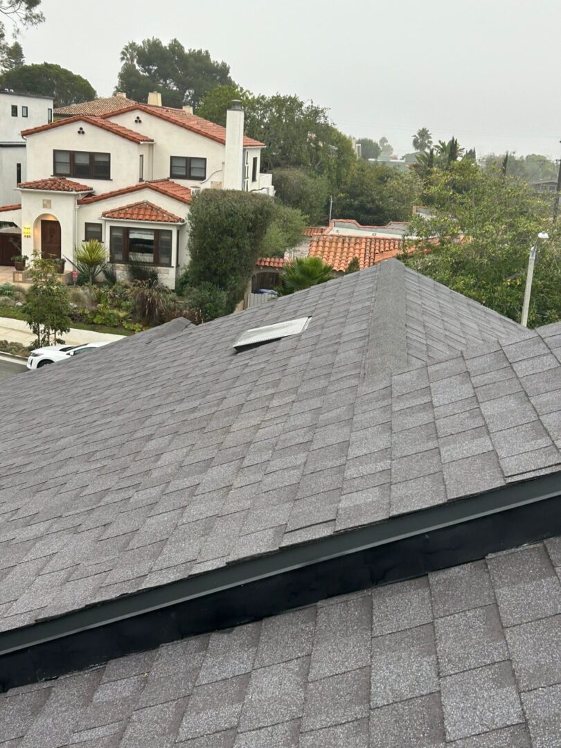 Newly installed gray asphalt shingle roof on a suburban house.