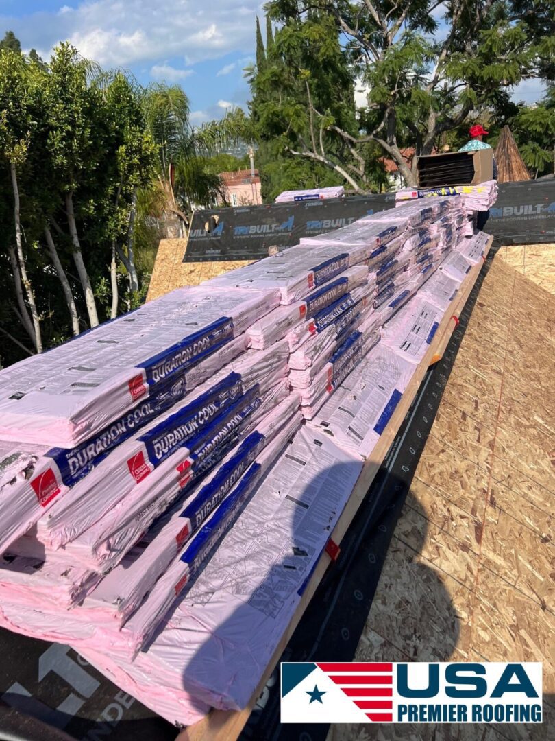 Stacks of pink insulation boards ready for installation on a roof.