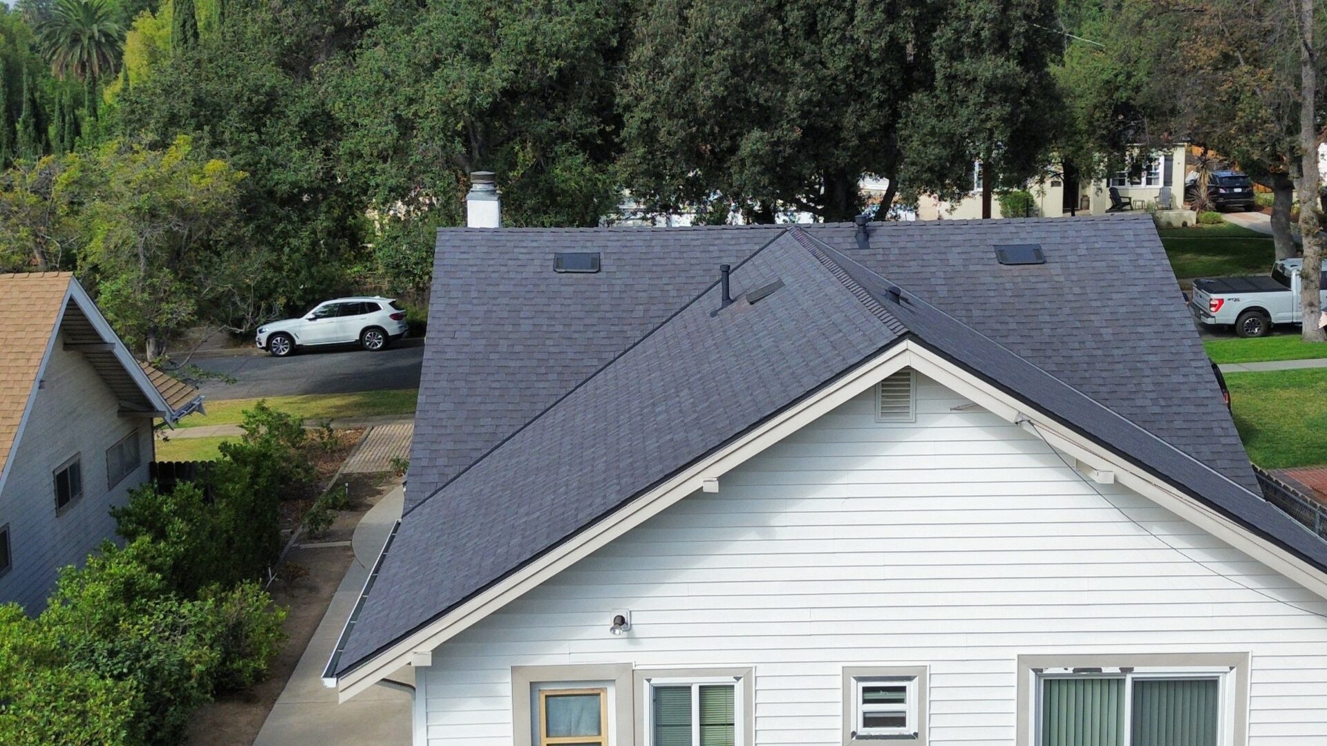 A house with a newly installed dark gray shingle roof.