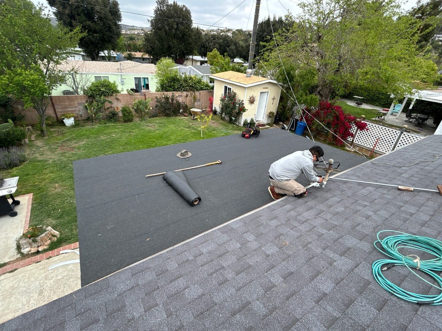 Worker installing a roof underlayment on a residential home.