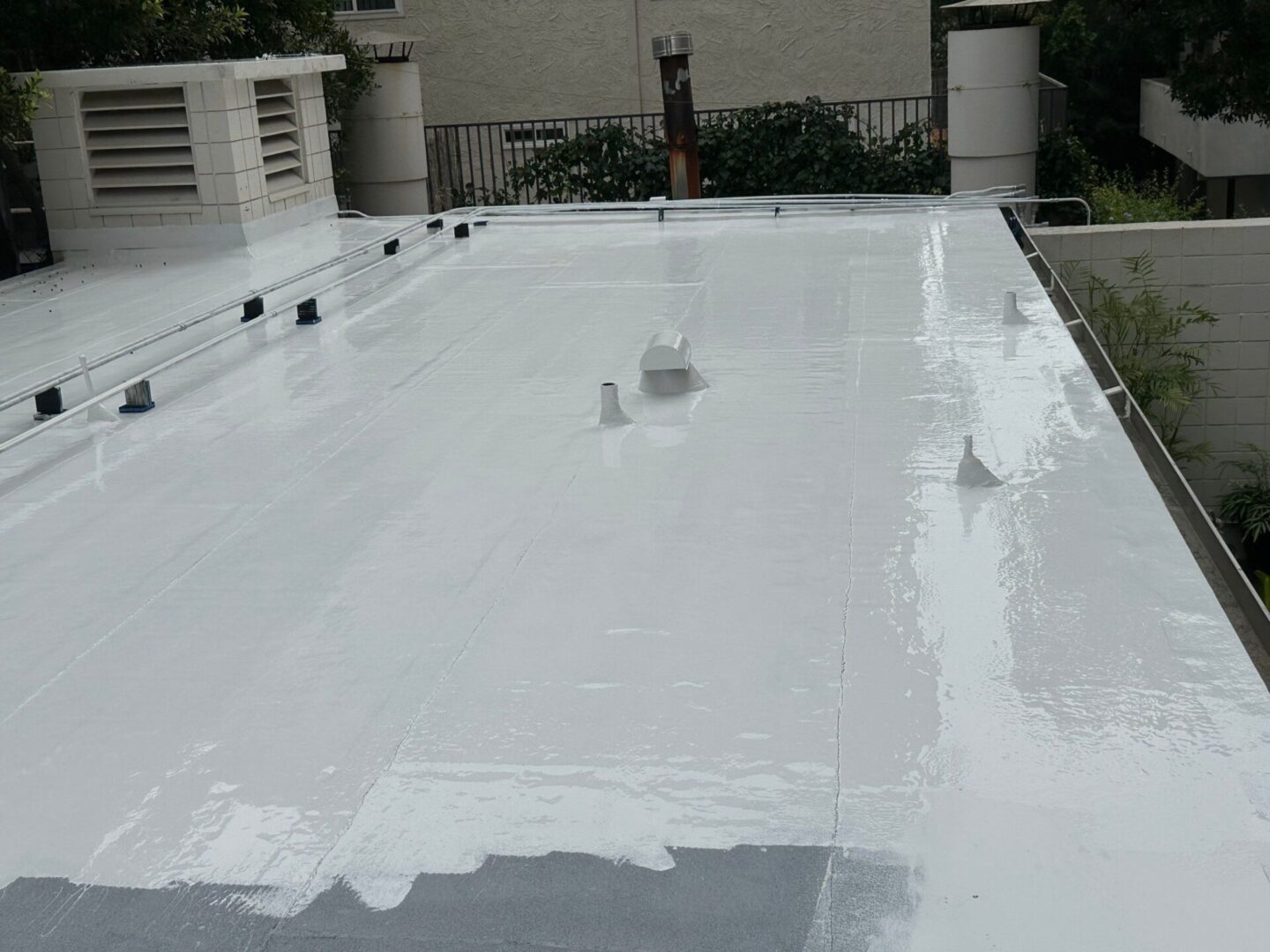 Flat rooftop with fresh white coating applied.