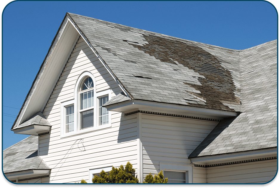 A house with a worn and damaged roof under clear blue sky.