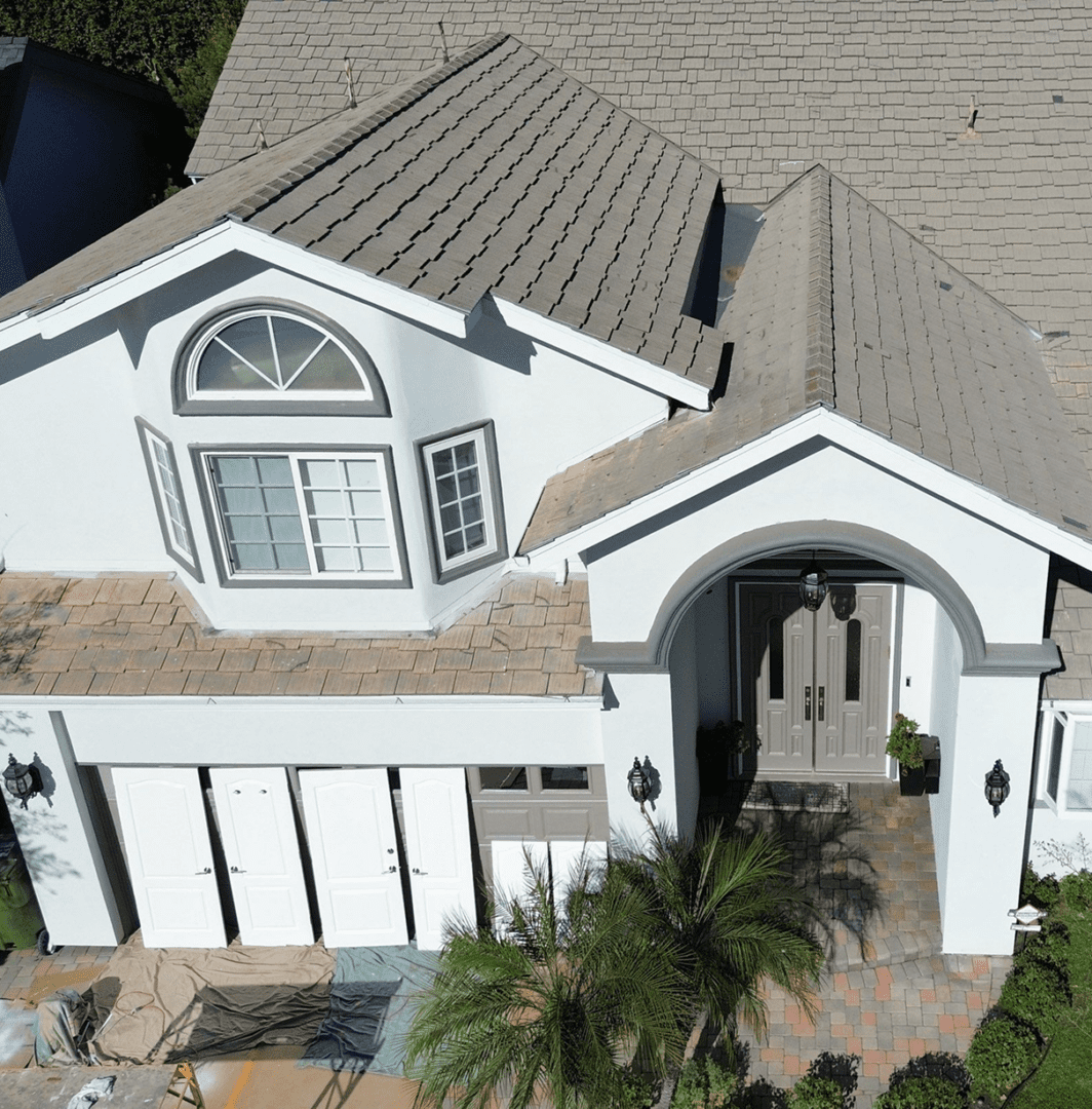 A modern two-story house with a gray roof and white exterior.